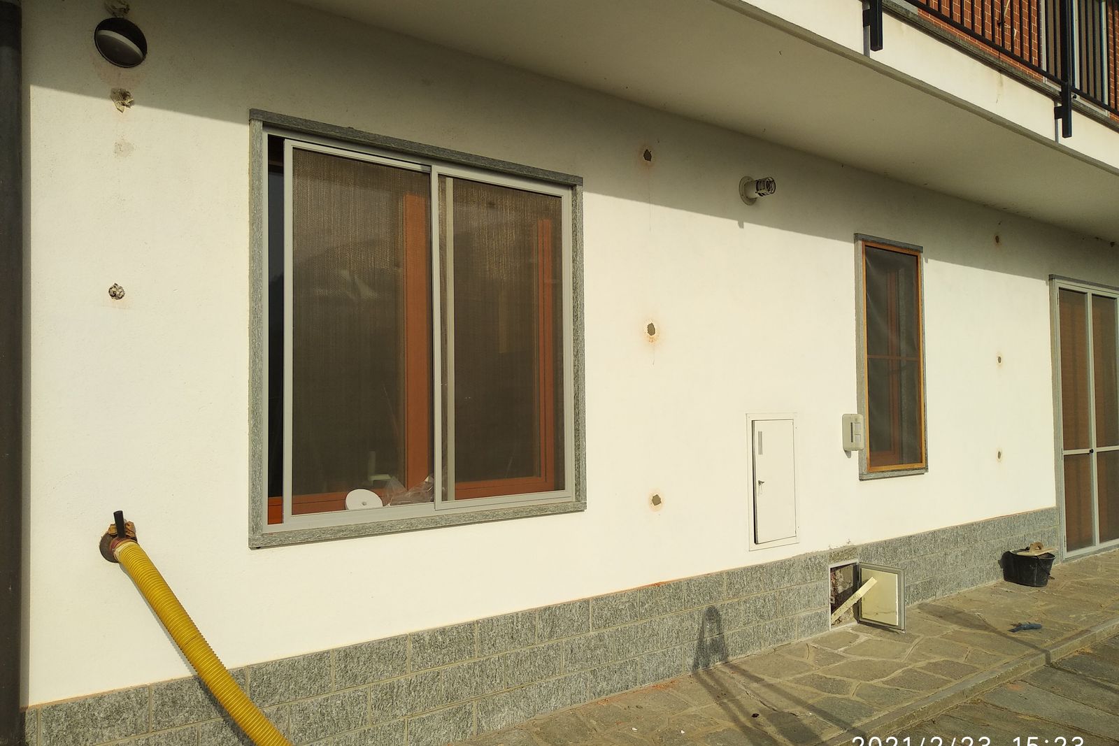 Muro esterno di una casa con la griglia dei fori e il tubo di insufflaggio inserito